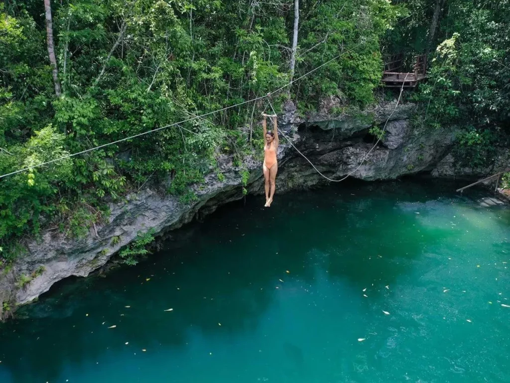 Girl on a zip line in cenote zapote
