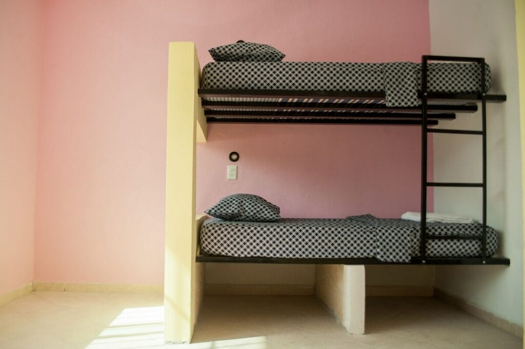 Chic bunk beds in a pink room in Coco Hostel.