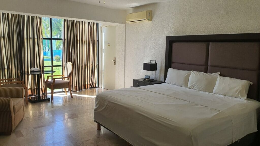 Nirvana Hotel and Hostel deluxe room with a cozy bed and balcony.
