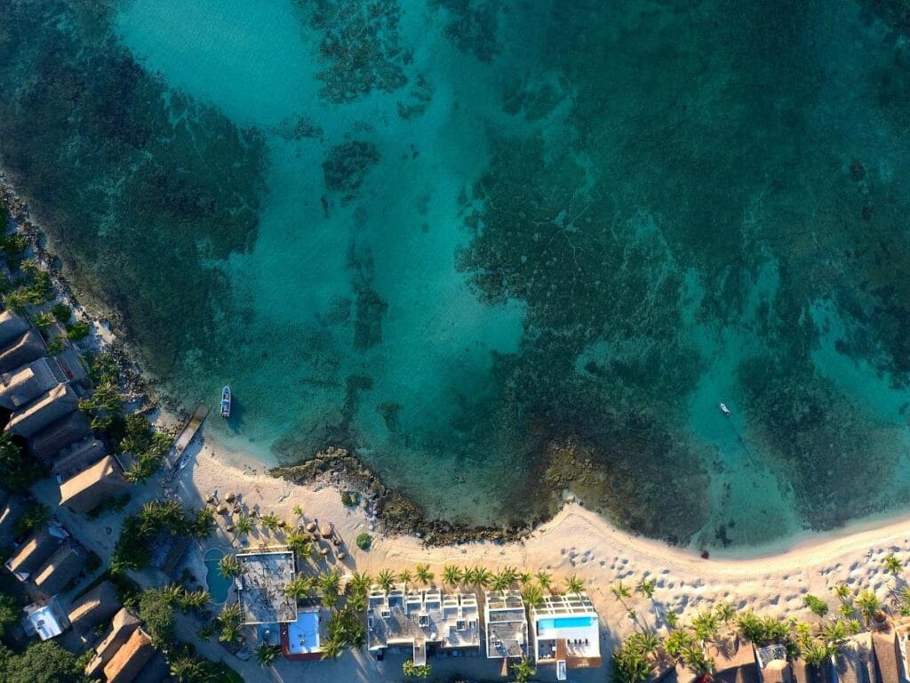 Aerial view of tropical beach and clear turquoise water.